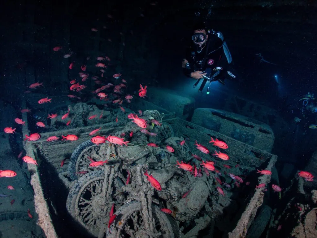 Scuba diver explores a sunken ship, SS Thistlegorm, filled with fish in total underwater silence in Red Sea