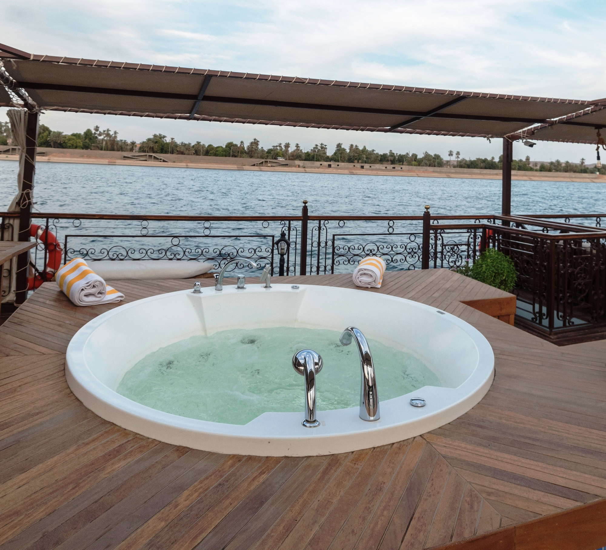 Jacuzzi on luxury Nile River cruise ship deck with palm trees in Egypt