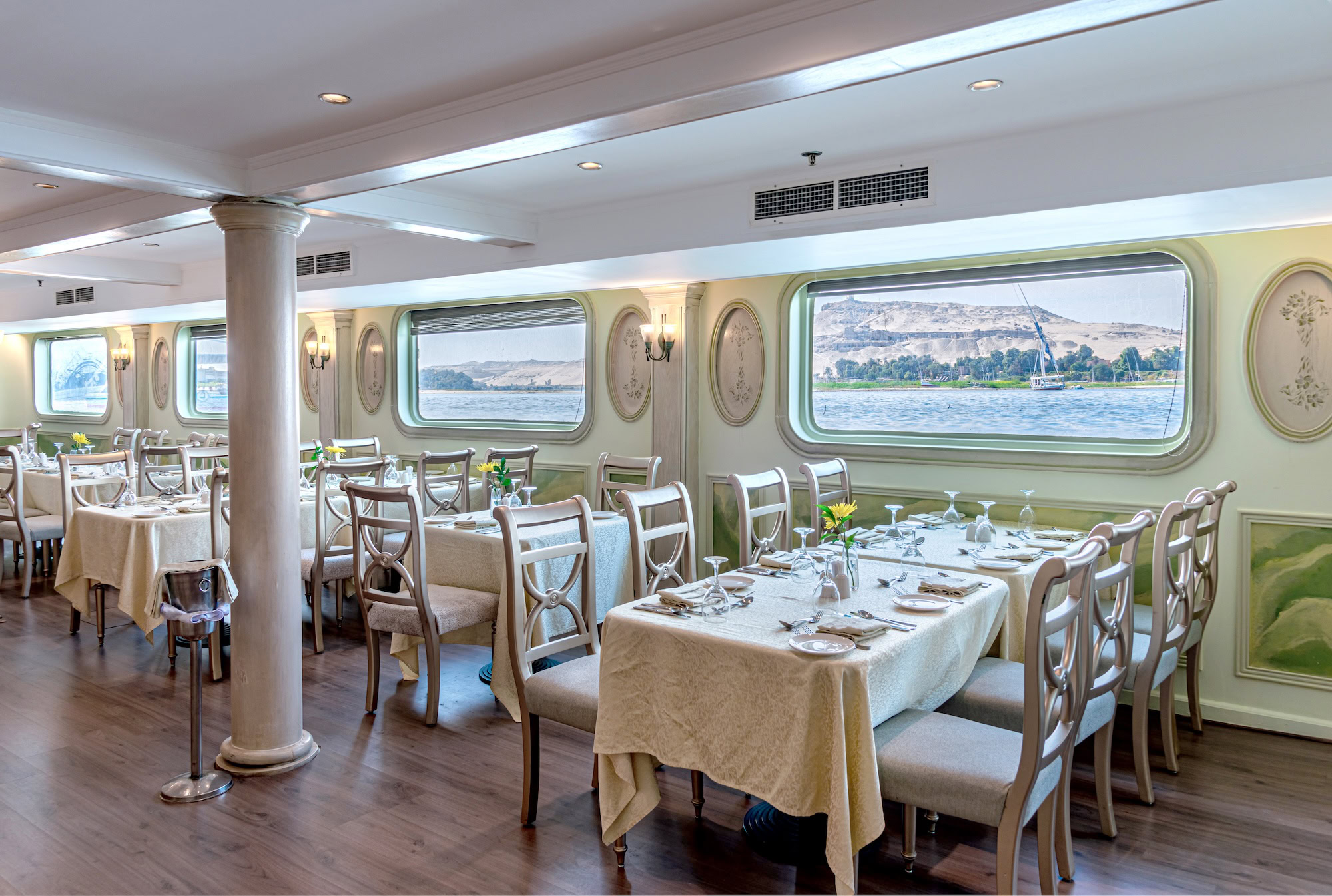 Elegant dining room aboard a Nile River cruise ship with set tables and river view