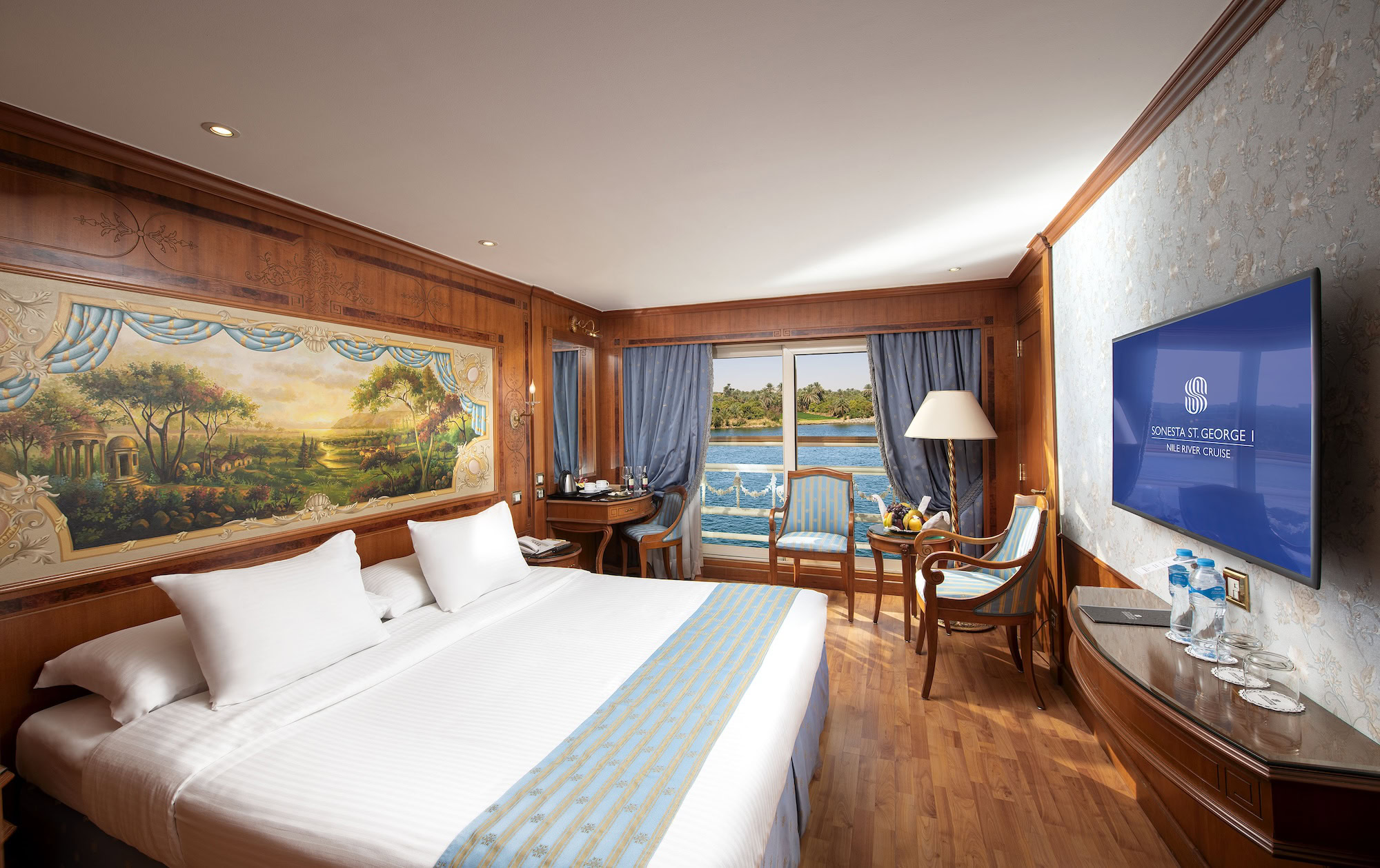Luxurious Nile cruise ship cabin interior with bed, TV, and river view