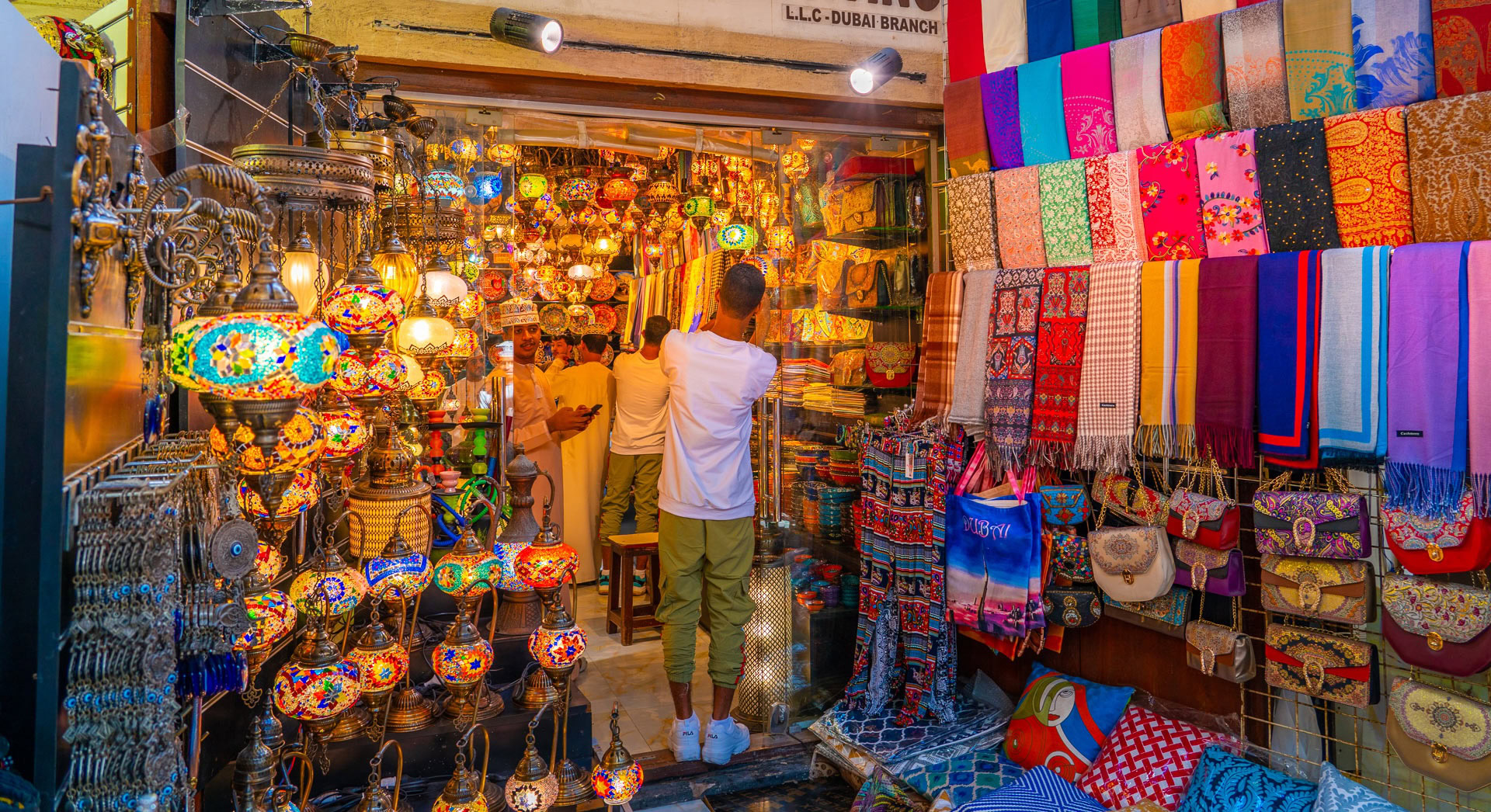 Vibrant Dubai souk displaying traditional lamps, textiles, carpets and crafts