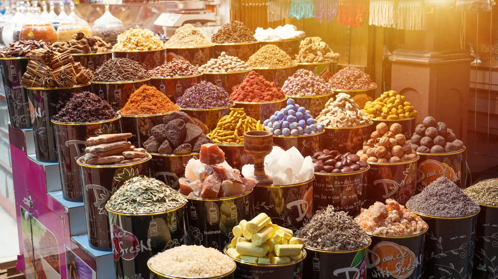 Traditional spice market display with colorful spices, herbs, and dried fruits arranged in containers at Dubai Spice Souk