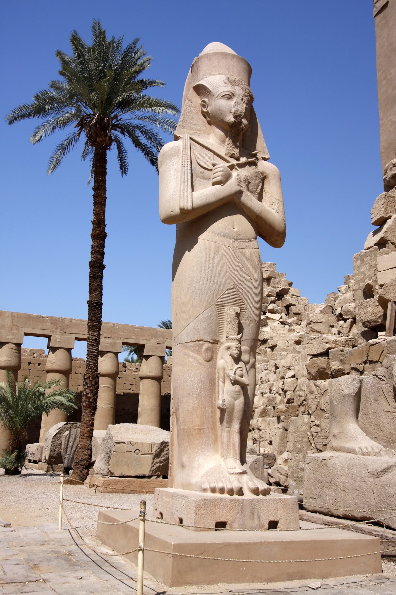Pharaoh statue with ancient columns at Karnak Temple Complex in Luxor, Egypt