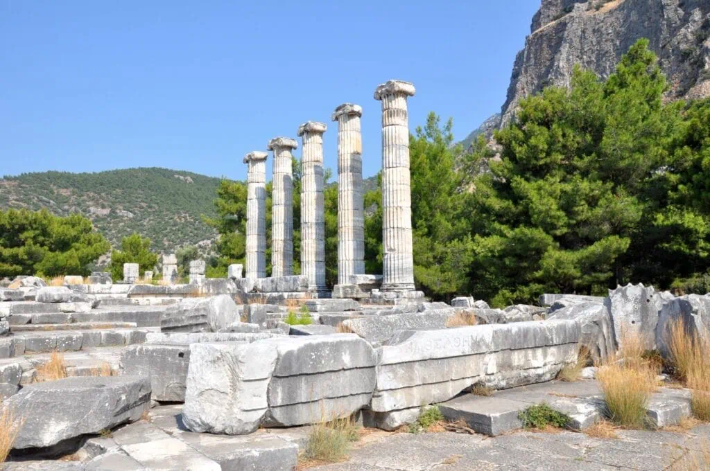Stone column ruins and stepped platform on a hillside overlooking the plain at Temple of Athena Polias, Priene