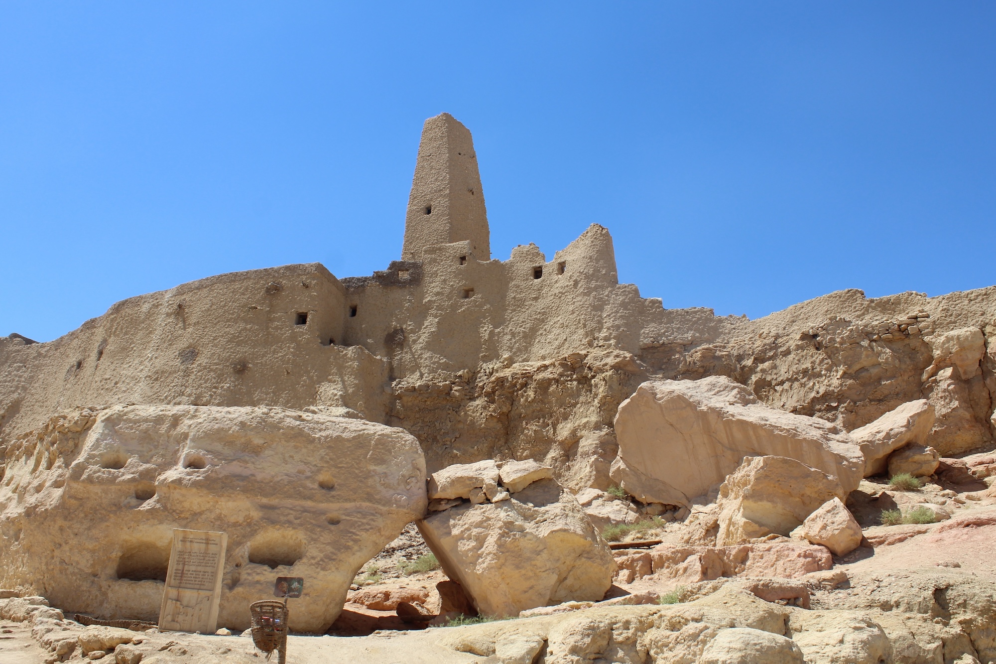 Ancient ruins of the Temple of the Oracle at Siwa Oasis with mud brick walls and stone blocks