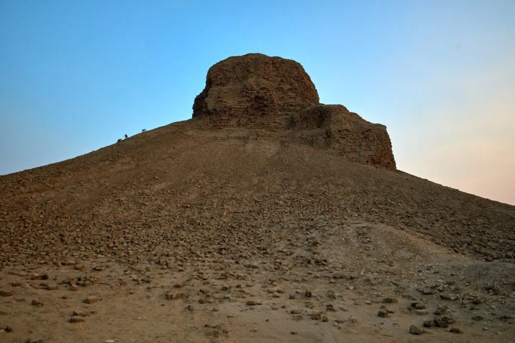 The eroded Black Pyramid of Amenemhat III at Dahshur rising above the desert plateau, with the dark mudbrick core exposed against the surrounding sand