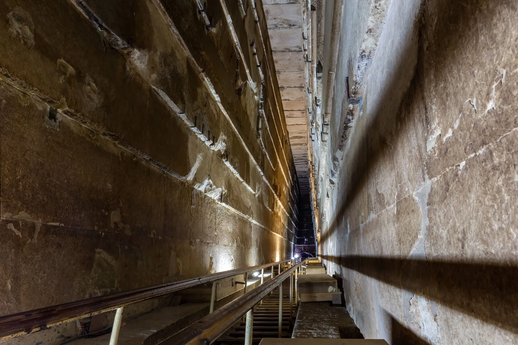 The Grand Gallery inside the Great Pyramid of Giza, showing the ascending stone corridor with corbelled limestone walls and ramps along both sides - Giza Pyramids Tours