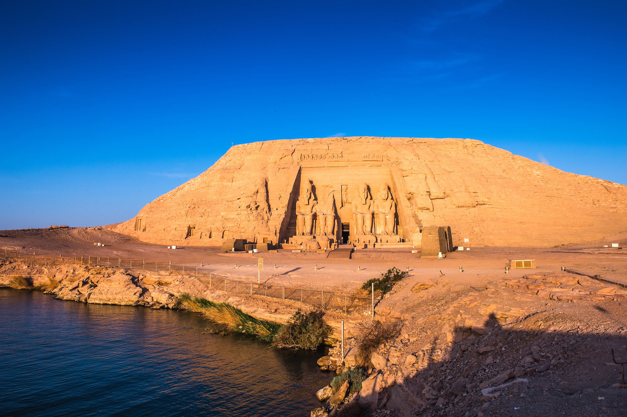 Templi di Abu Simbel con statue colossali di faraone sulla riva del lago
