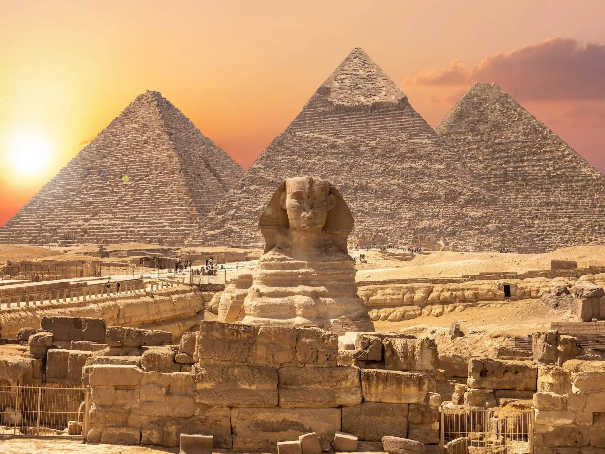 The Great Sphinx and the three Pyramids of Giza near Cairo at dusk with visitors, the opening highlight of a classic 7-to-10-day guided Egypt all-inclusive tour.