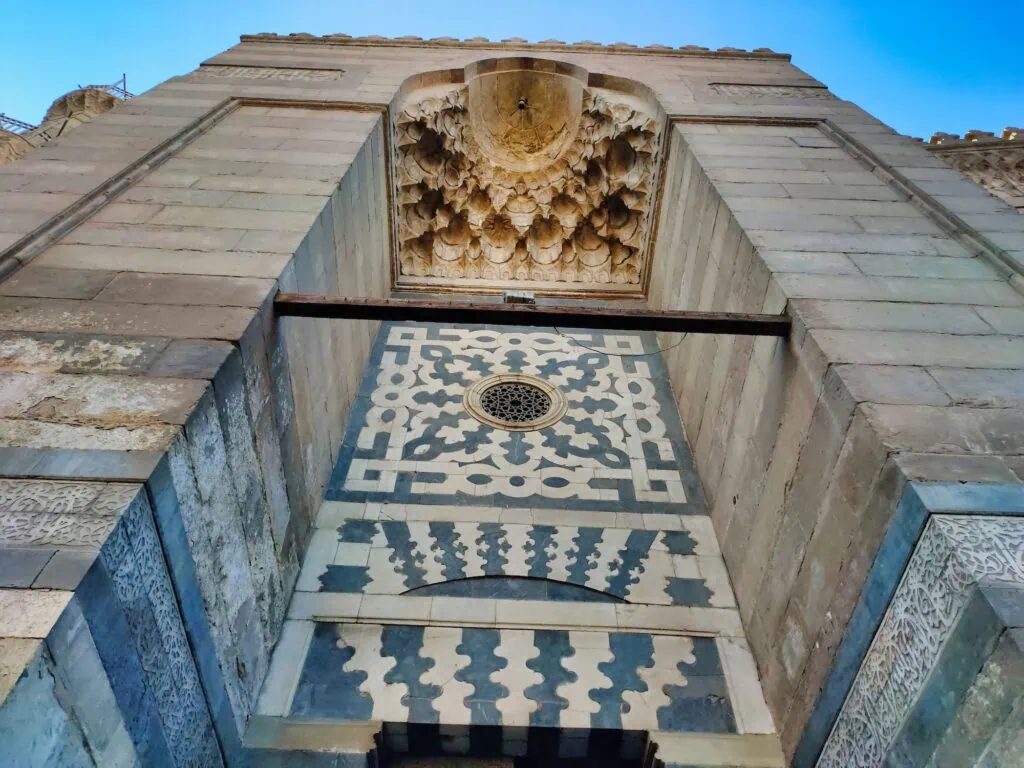 Stone entrance facade of the Sultan al-Ghuri Complex with carved muqarnas and geometric stone inlay, Sultan al-Ghuri Complex, Cairo
