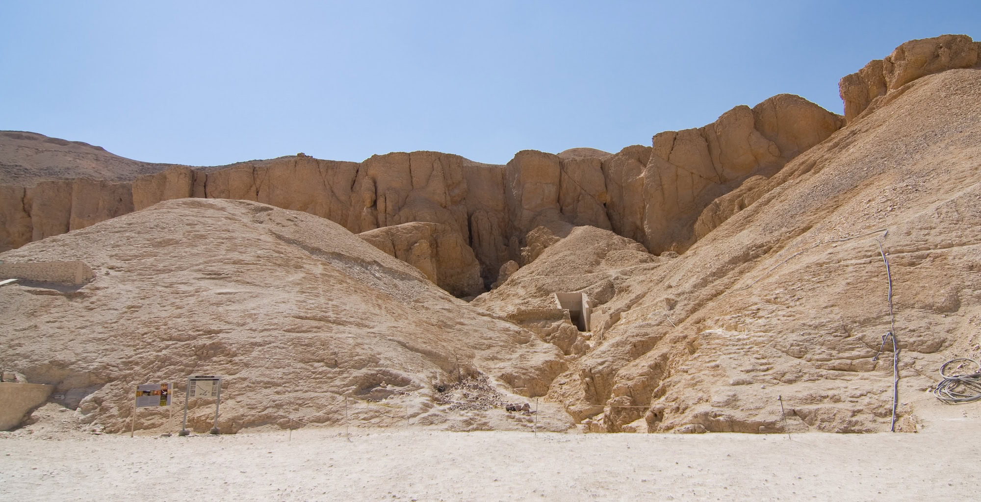 Valley of the Kings tomb entrance with limestone cliffs and desert landscape
