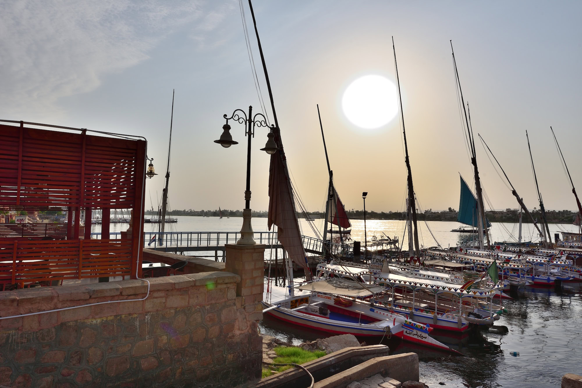 Felucca sailboats on the Nile River waterfront in Aswan at sunset