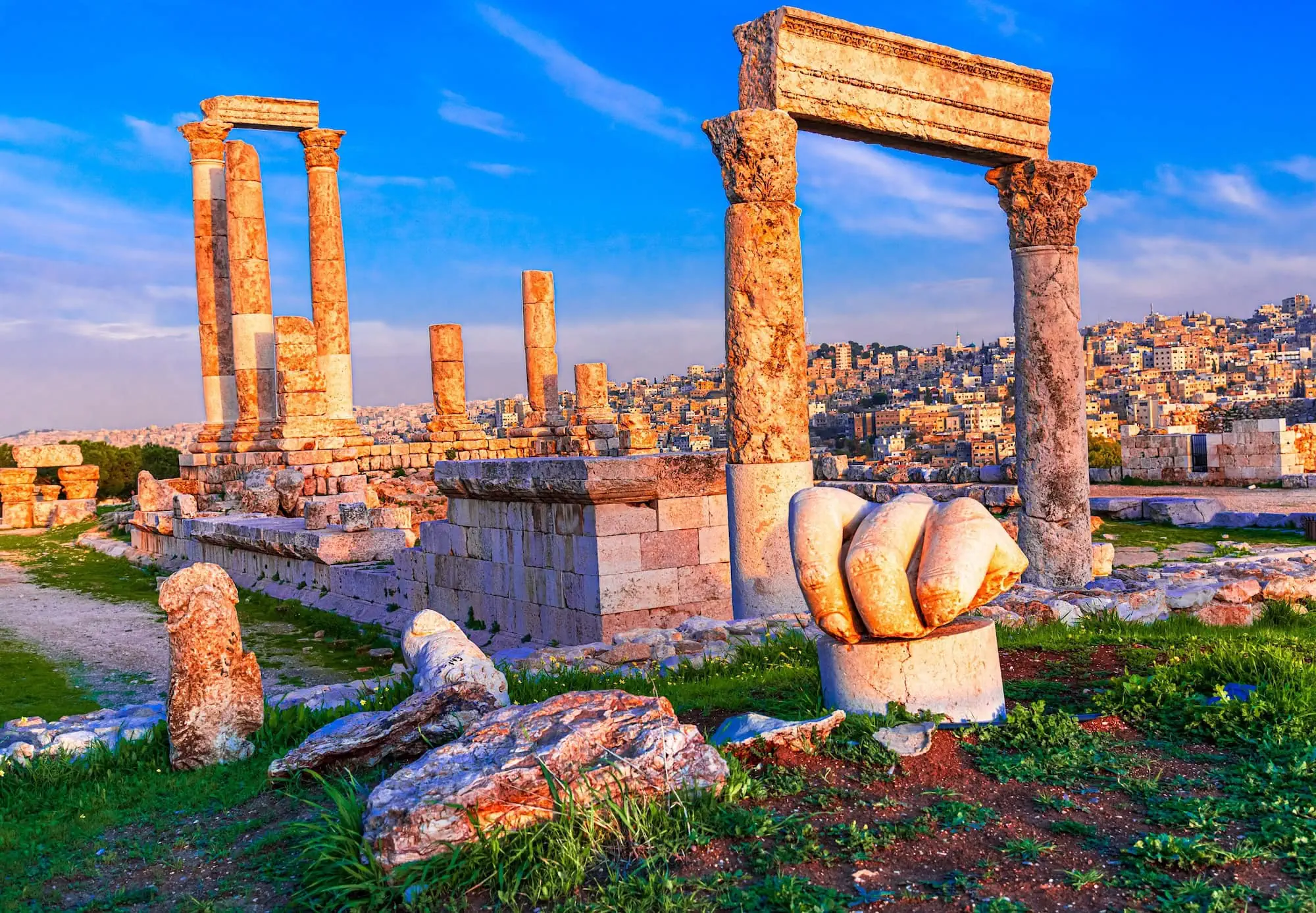 Roman Temple of Hercules ruins with stone columns and carved hand sculpture at sunset
