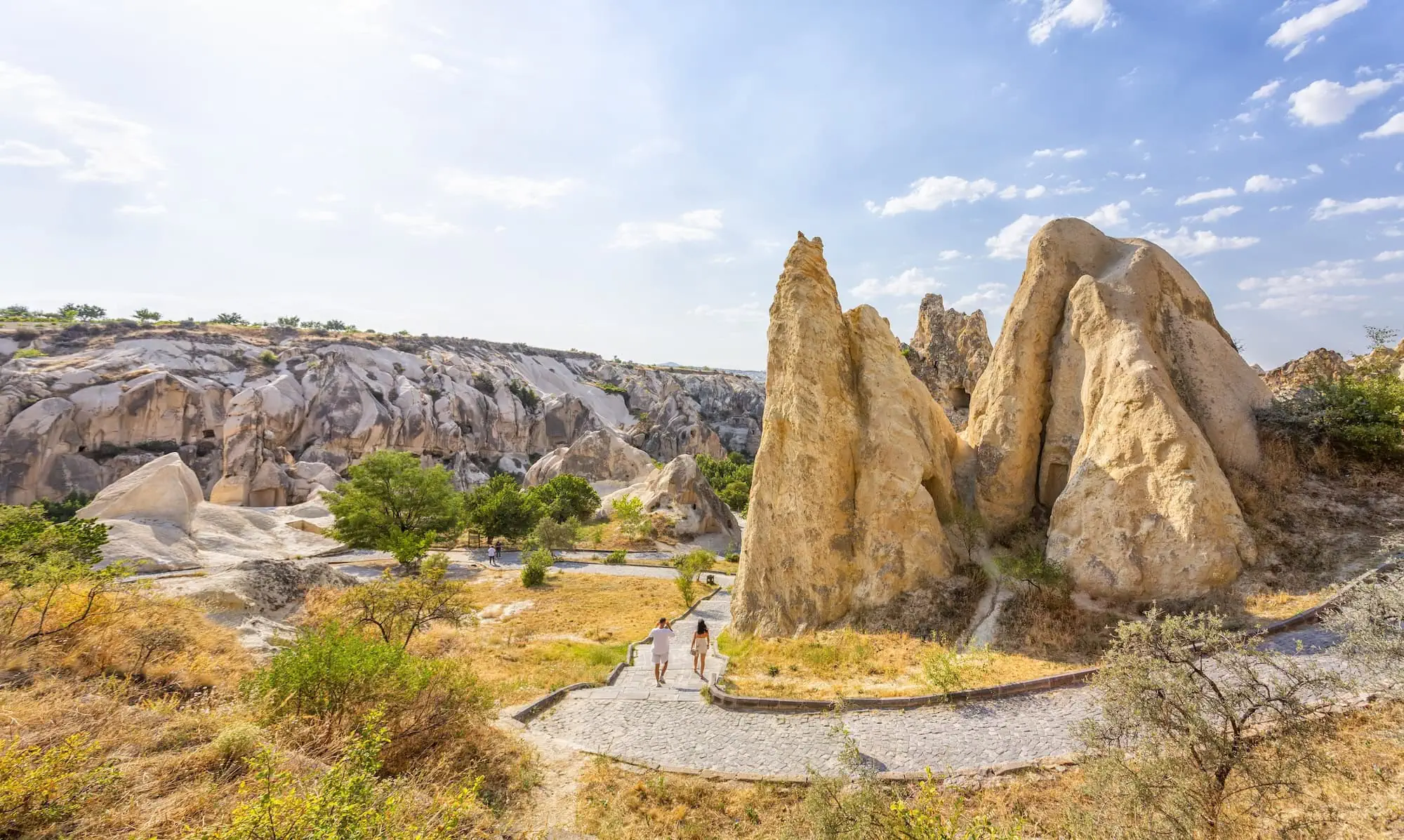 Cappadocia's unique fairy chimney rock formations with tourists on stone pathway