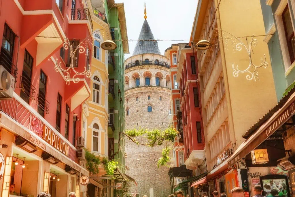 Galata Tower rising above surrounding buildings viewed through a narrow passage in the Pera district, Istanbul
