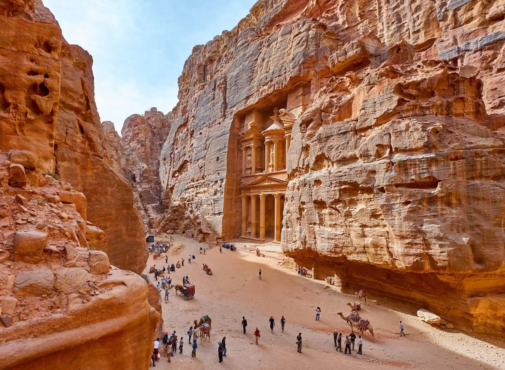 Il famoso Tesoro di Petra con turisti e cammelli nella gola di roccia arenaria