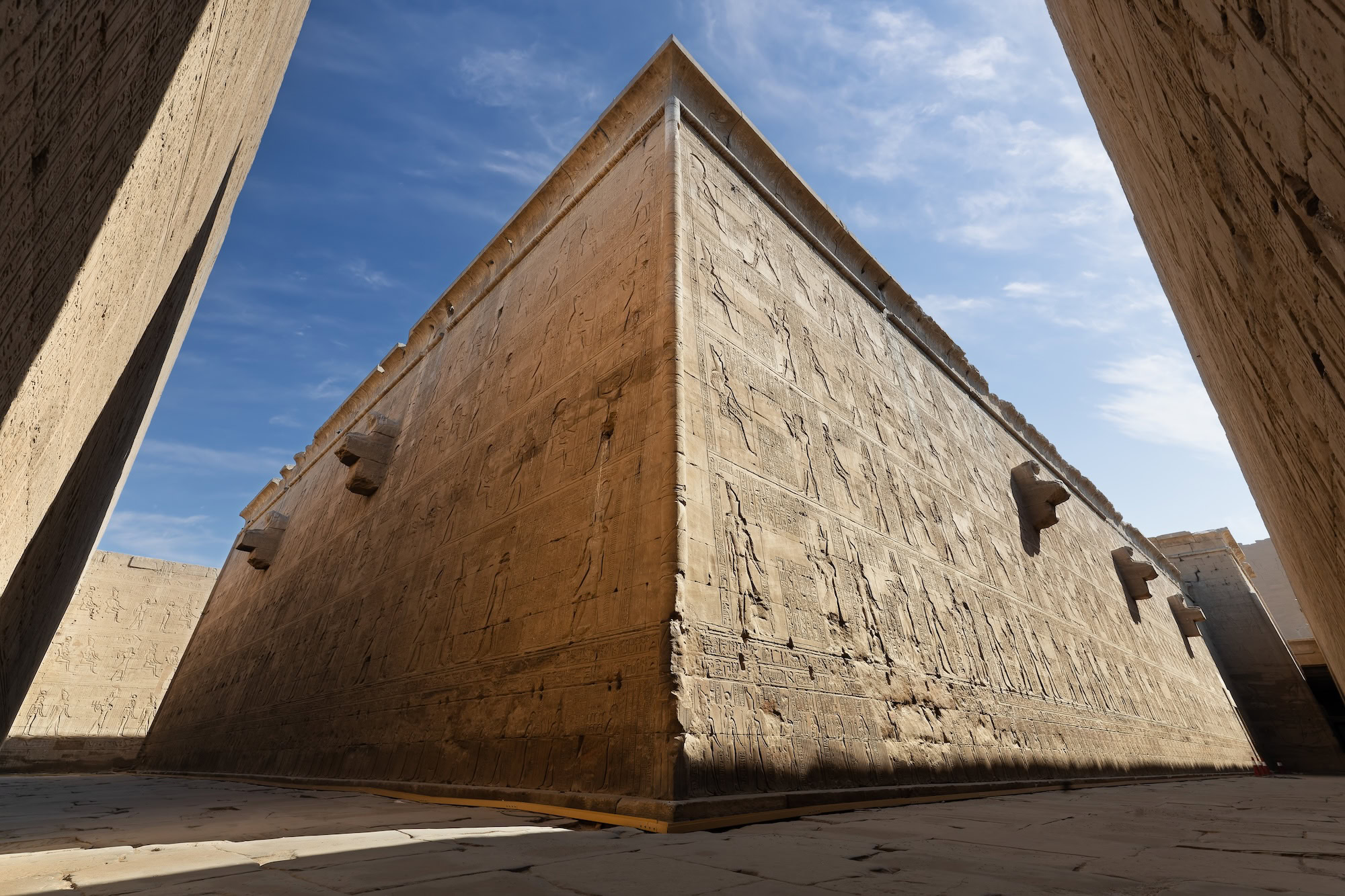 Templo egípcio antigo com pátio e hieróglifos nas paredes de pedra