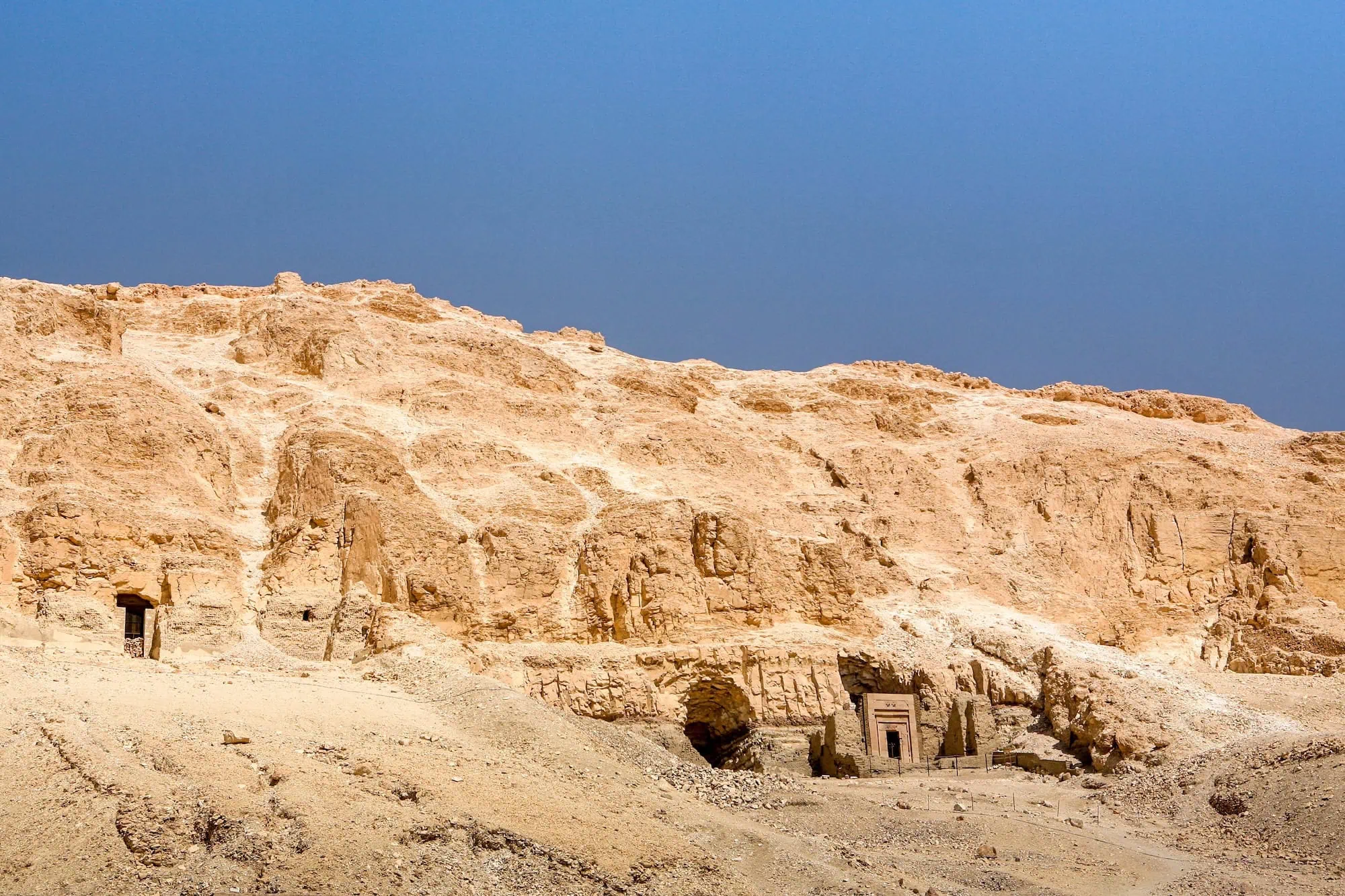 Ancient tomb entrances carved into limestone cliffs in the Valley of the Kings