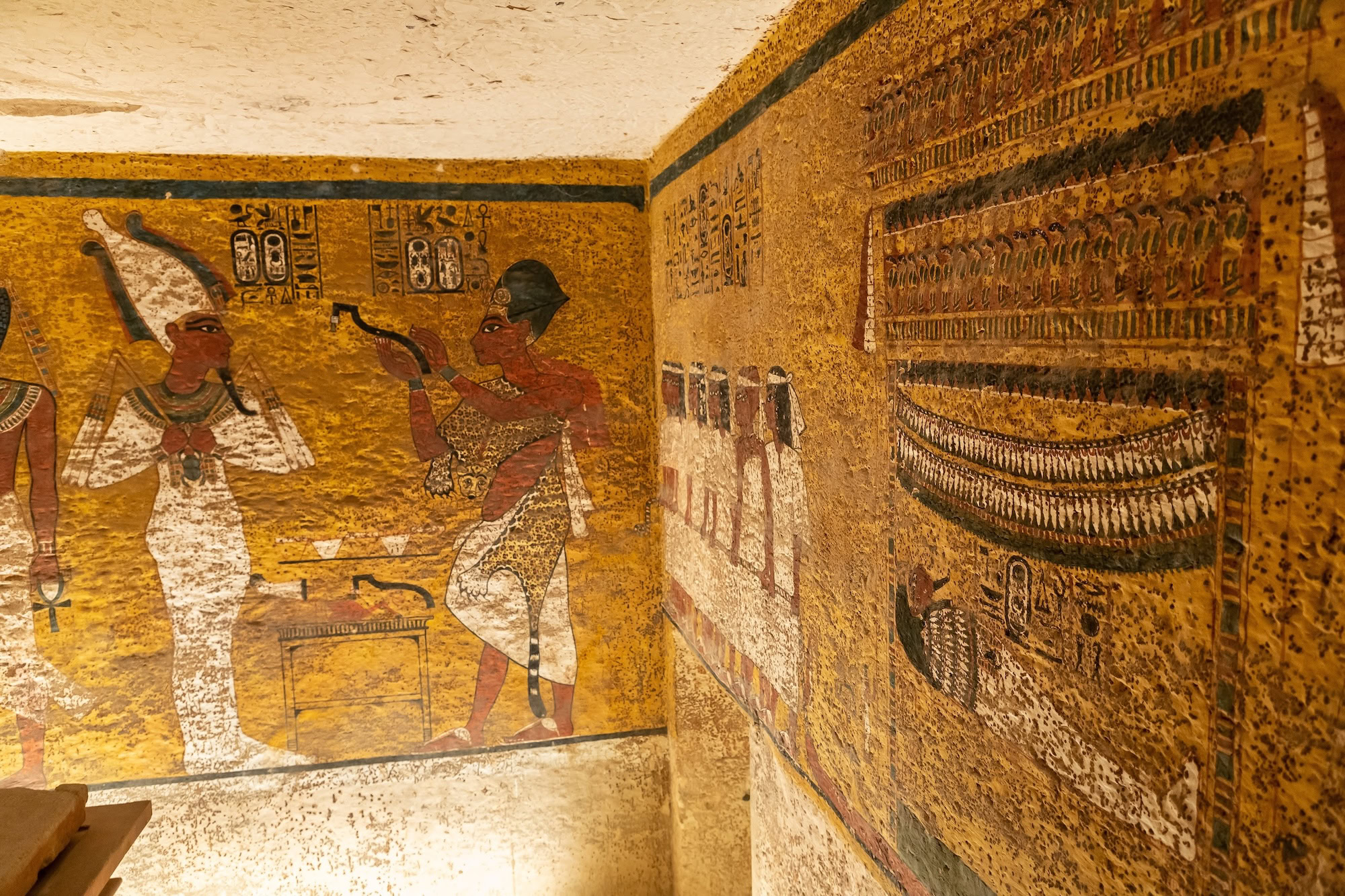 Ancient Egyptian tomb chamber with hieroglyphic wall paintings and ceremonial artwork