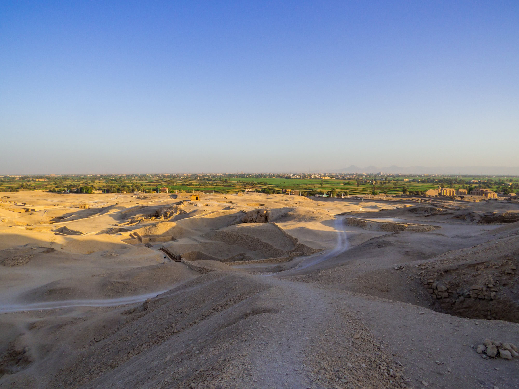 Sitio arqueológico egipcio con excavaciones mostrando ruinas de templo desenterradas