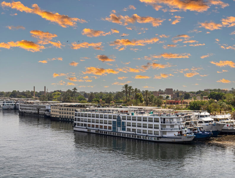 Tourist cruise ships on the Nile river anchored in the tourist port. Sunset light