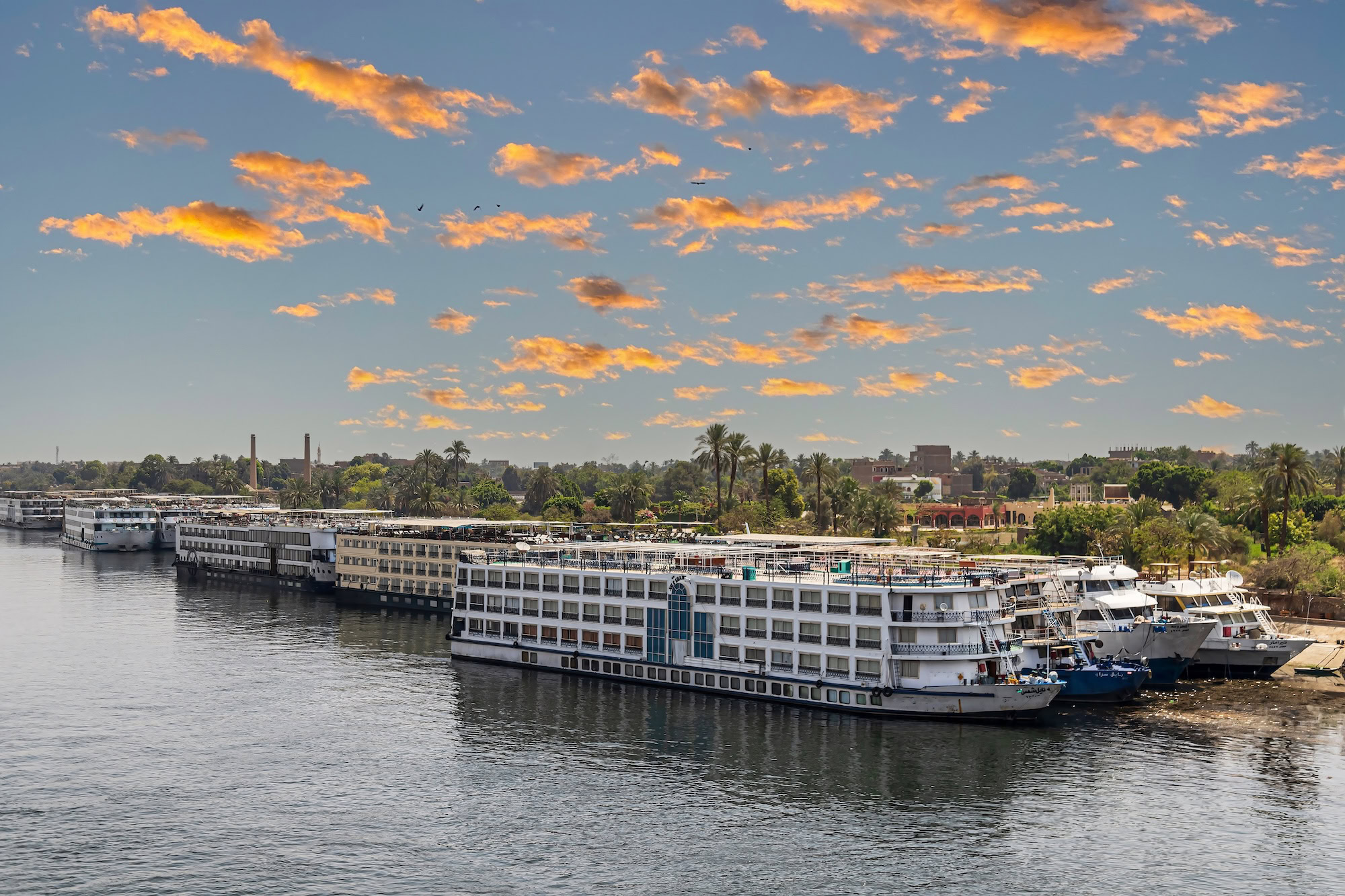 Tourist cruise ships on the Nile river anchored in the tourist port. Sunset light