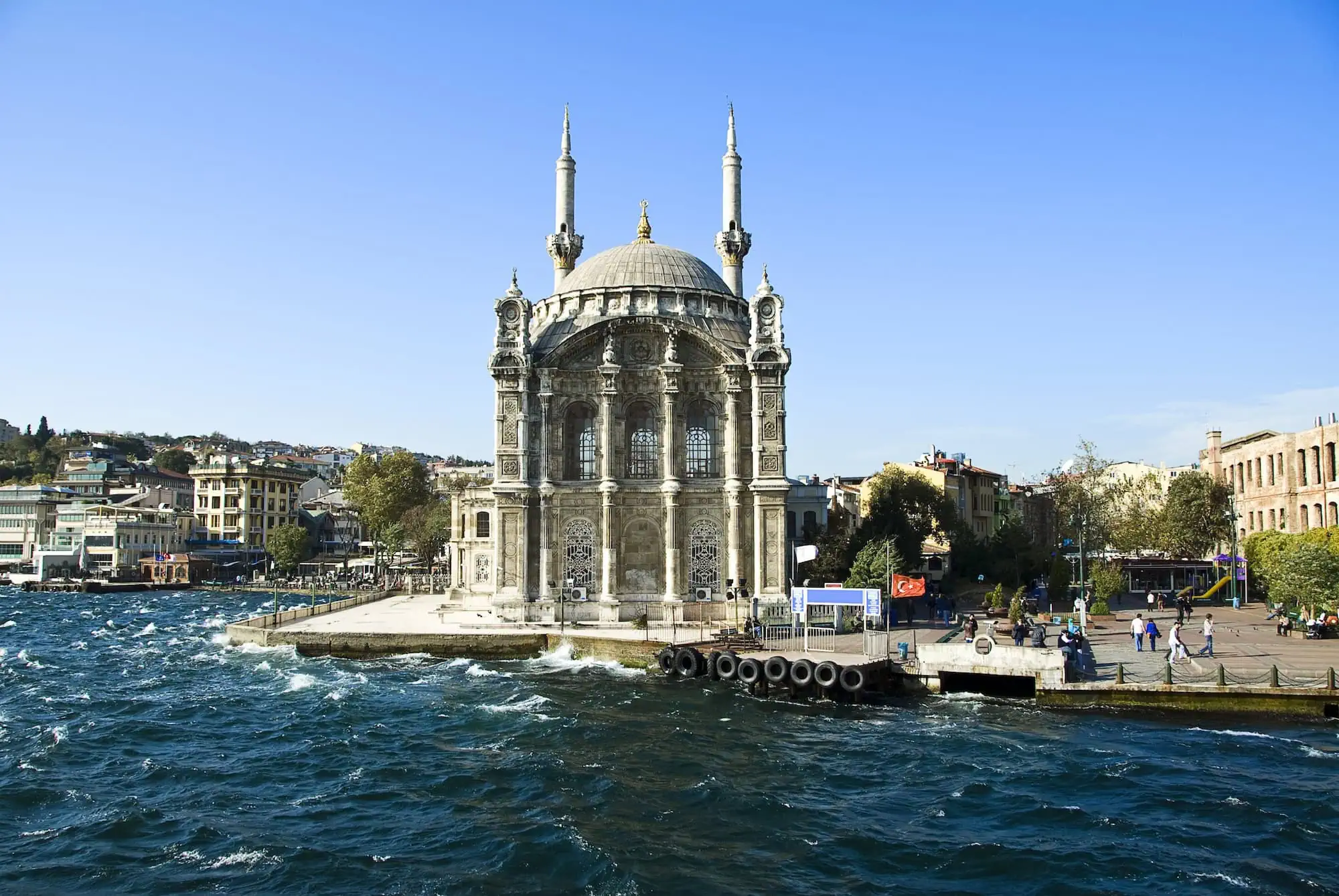 Ortaköy Mosque on the Bosphorus waterfront in Istanbul with visitors and traditional Ottoman architecture