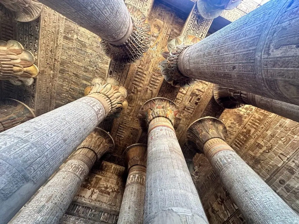 The Roman-era painted ceiling of the Temple of Khnum at Esna, Egypt — astronomical figures, zodiac scenes, and Egyptian deities painted in vivid red, blue, and gold pigment, recently revealed after a multi-year restoration removing centuries of soot