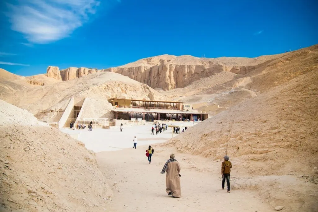 Visitors walking among the tomb entrances at the Valley of the Kings, the New Kingdom royal burial ground on Luxor's west bank, Egypt.