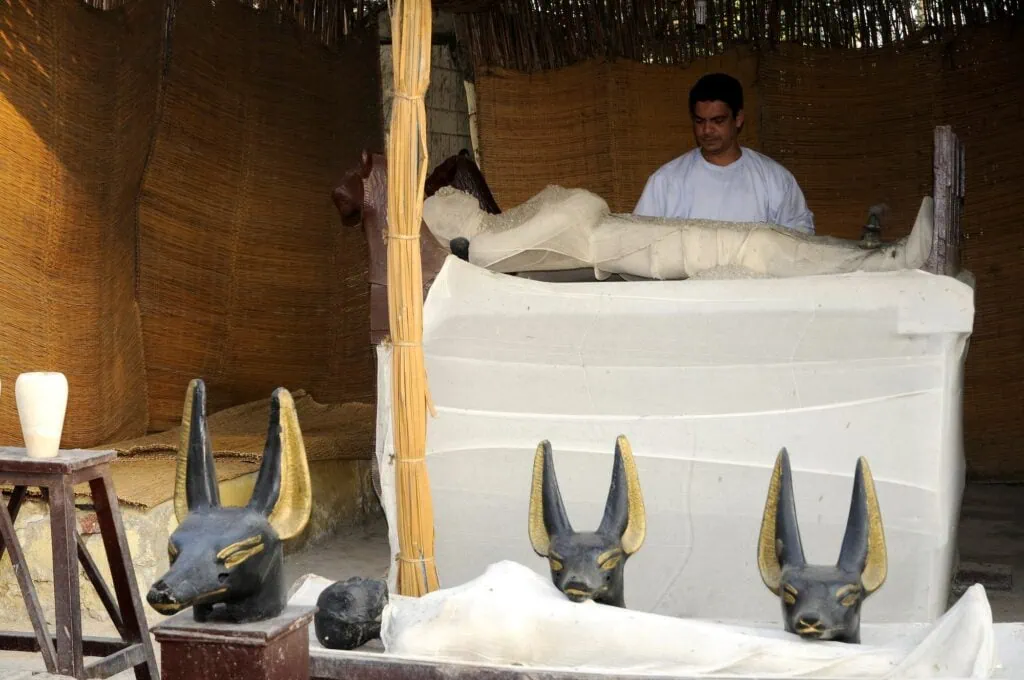 Reconstruction of the mummification process with wrapped figures and Anubis statues at the Valley of the Golden Mummies, Bahariya Oasis