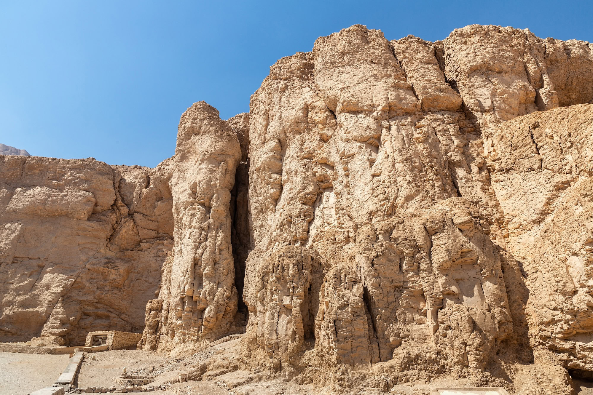 Ancient Egyptian tomb entrance carved into limestone cliff in Valley of the Kings