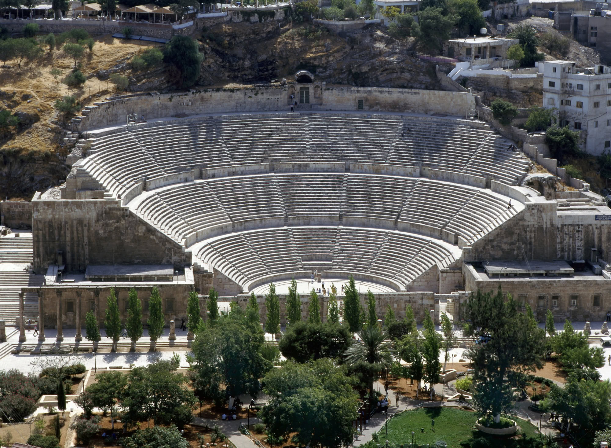 Ancient Roman Theatre amphitheater with stone seating overlooking modern Amman cityscape