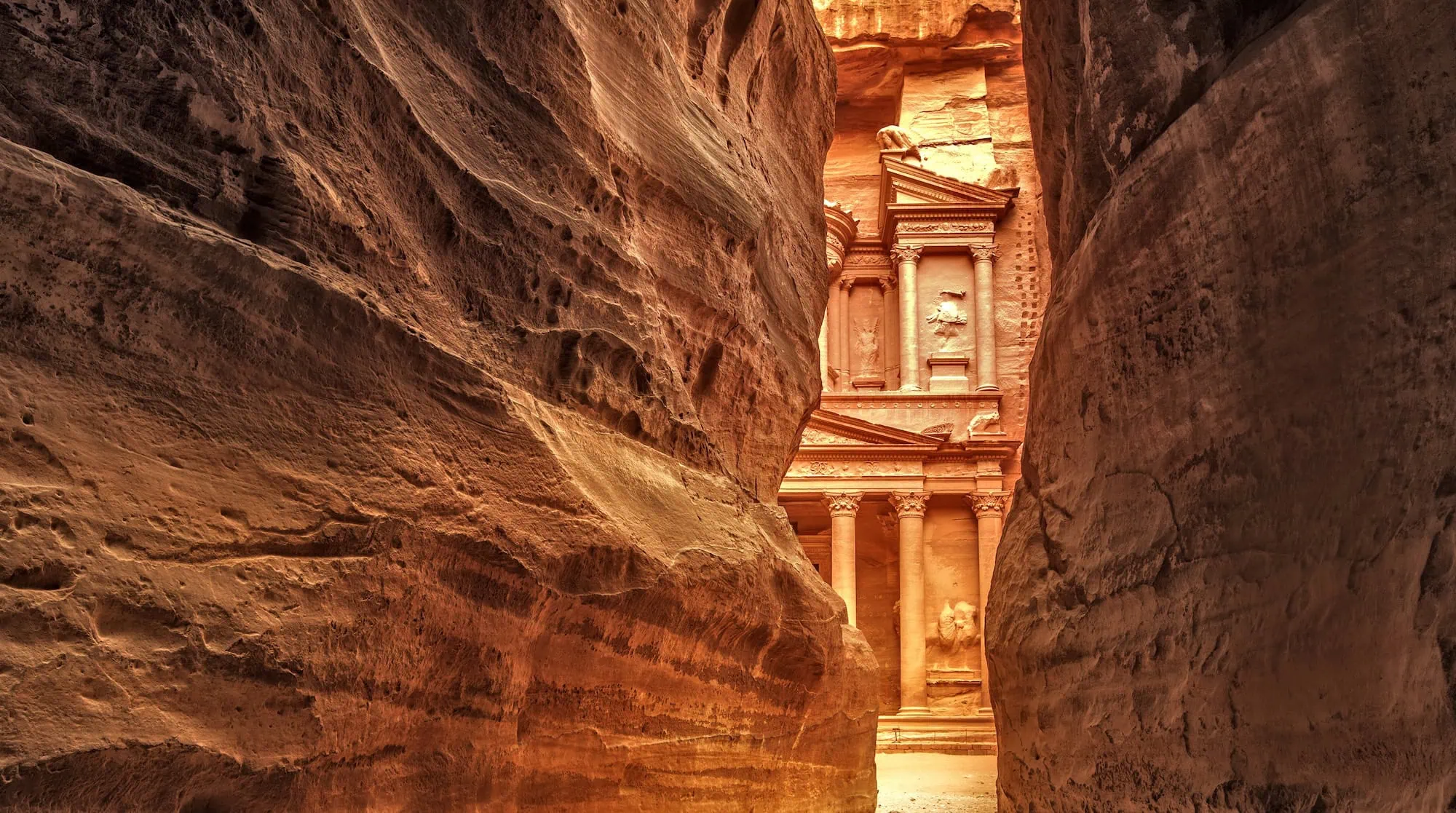 View through the Siq canyon entrance to the Treasury facade at Petra