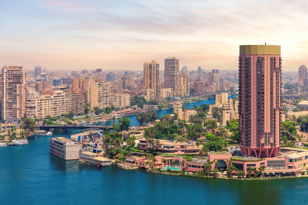 View across the Nile in Cairo with leafy Gezira Island midstream and the surrounding city skyline, the river setting many central Cairo hotels look out over on a private Egypt tour for seniors.