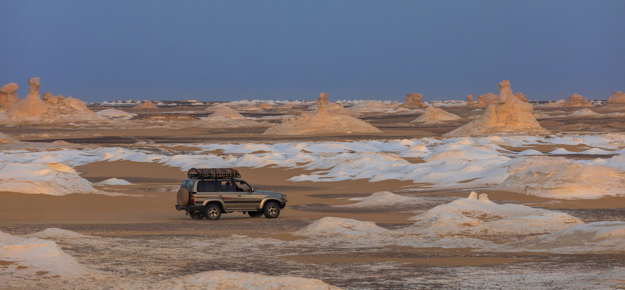 4x4 vehicle exploring limestone formations in Egypt's White Desert National Park