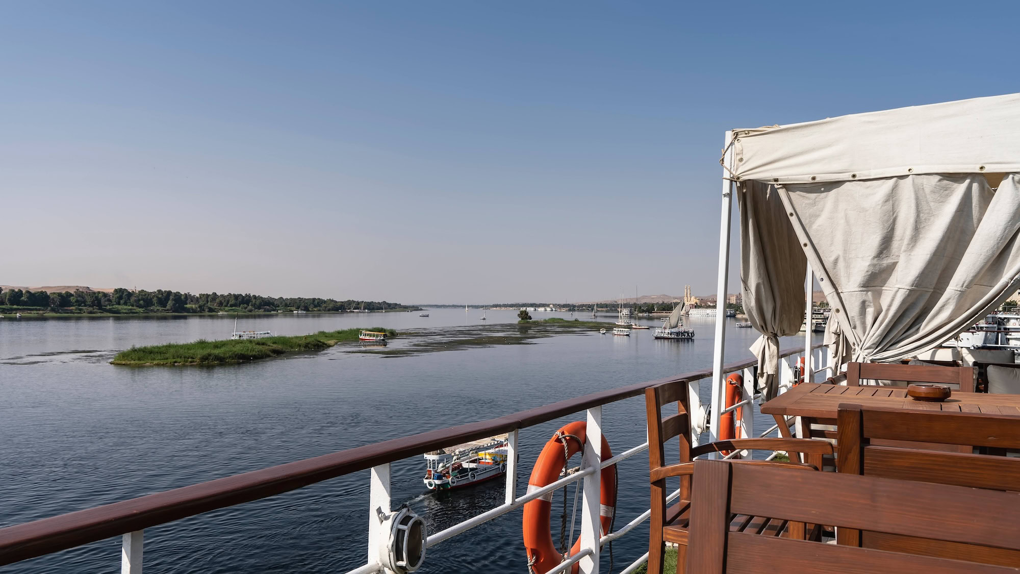 Convés de barco no Rio Nilo com mobiliário confortável e vista serena