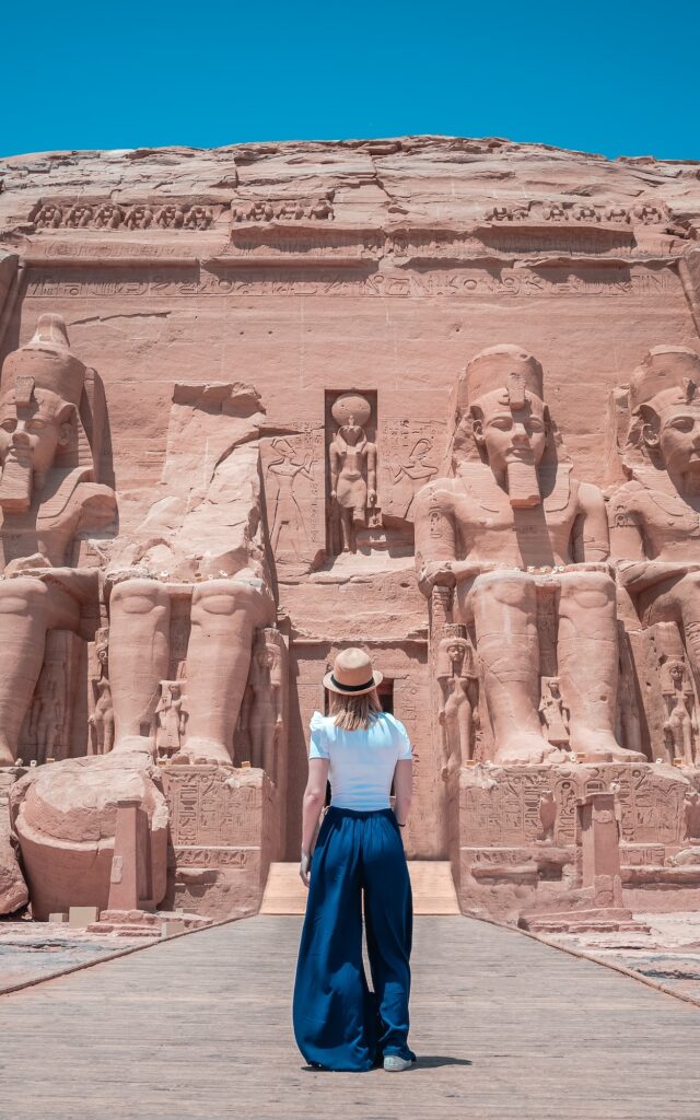 Young girl on her back enjoying the temple of Abu Simbel on her trip through Egypt