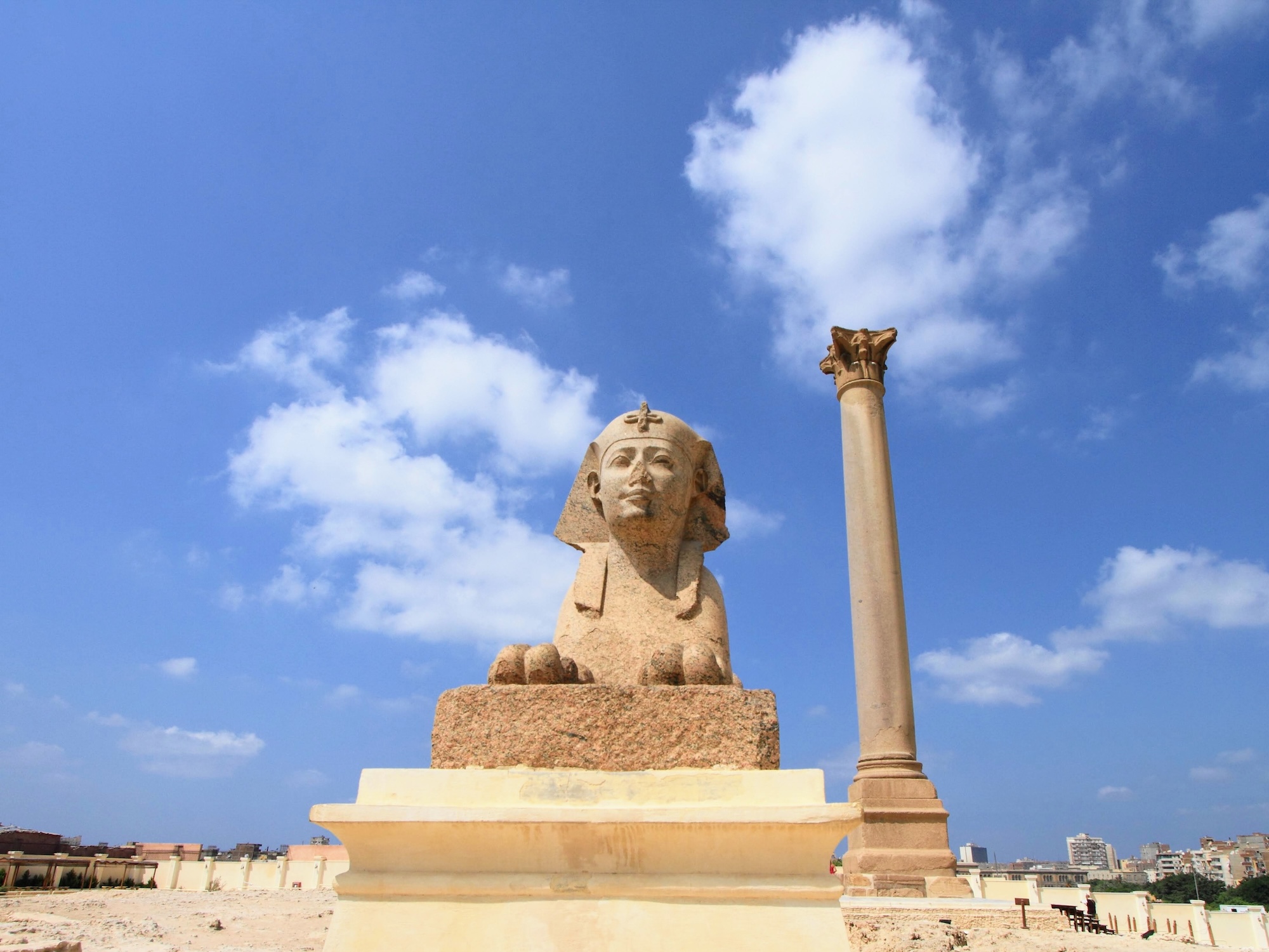 Ancient sphinx statue next to Pompey's Pillar column in Alexandria, Egypt