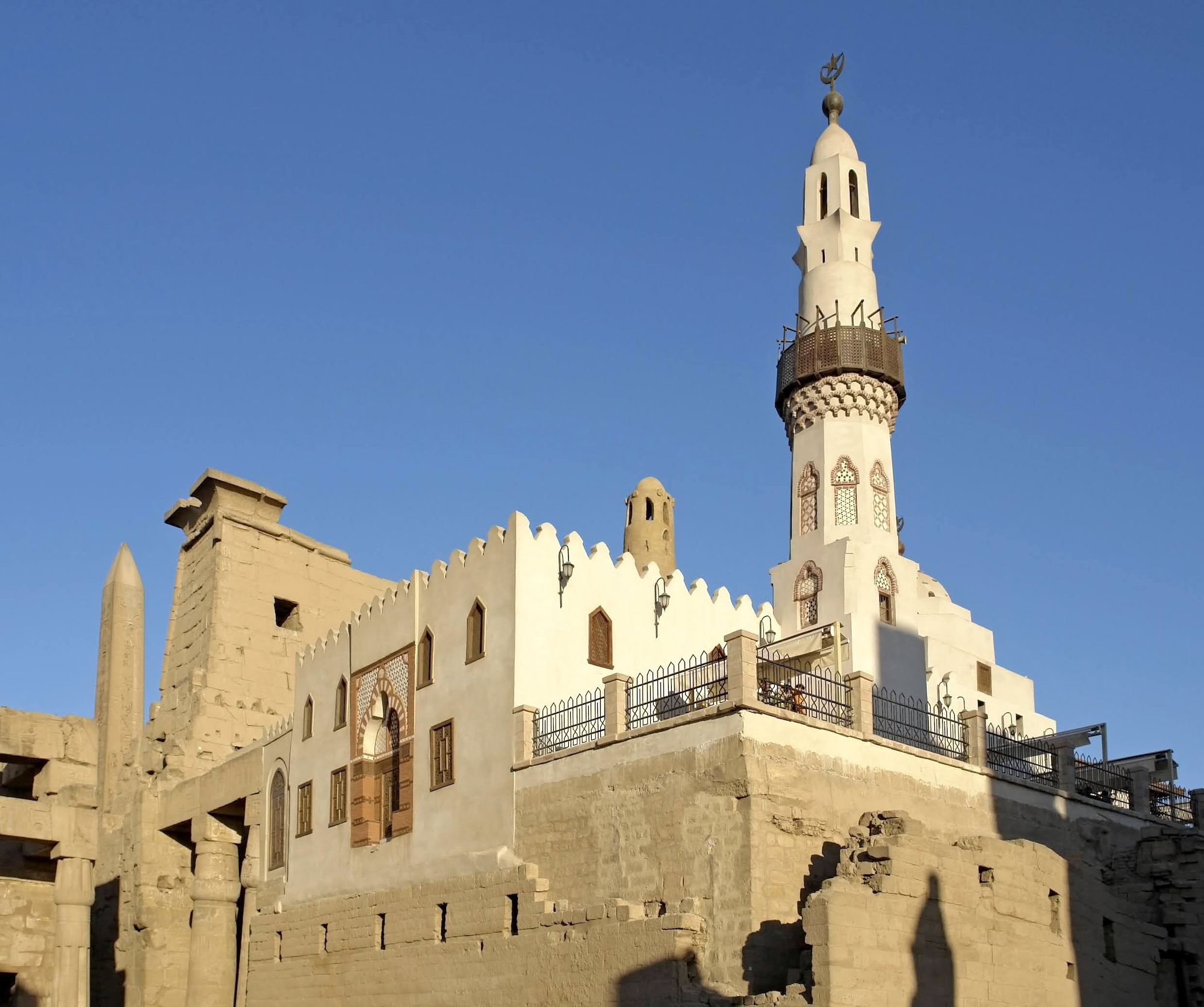 Traditional Islamic mosque with minaret and stone walls against clear sky