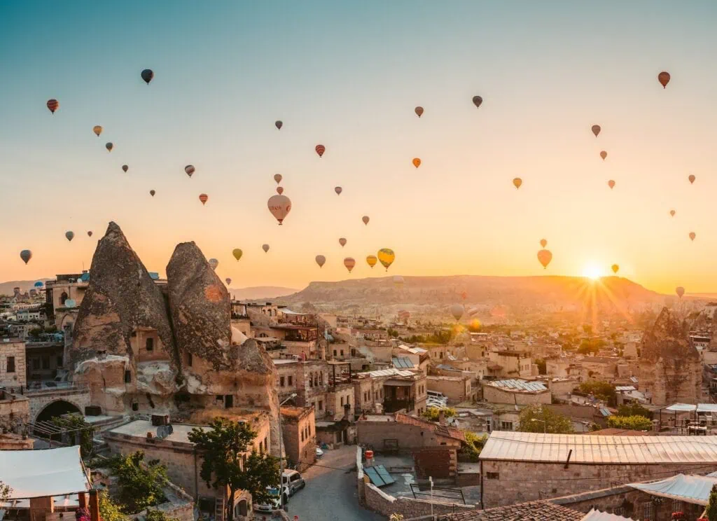 The fairy chimney rock formations in Cappadocia, Turkey — pyramid-shaped pillars of volcanic tuff topped with harder basalt caps, formed by erosion across the Göreme valley and surrounding region
