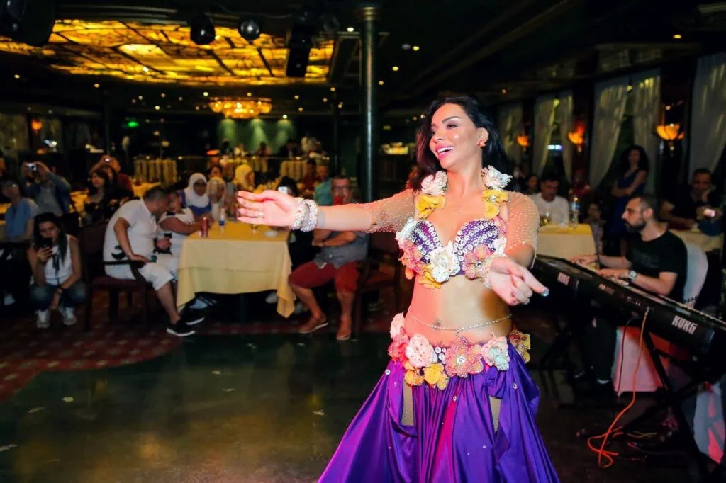 Egyptian belly dancer performing in traditional costume during an onboard evening show, Nile cruise performance venue, Luxor