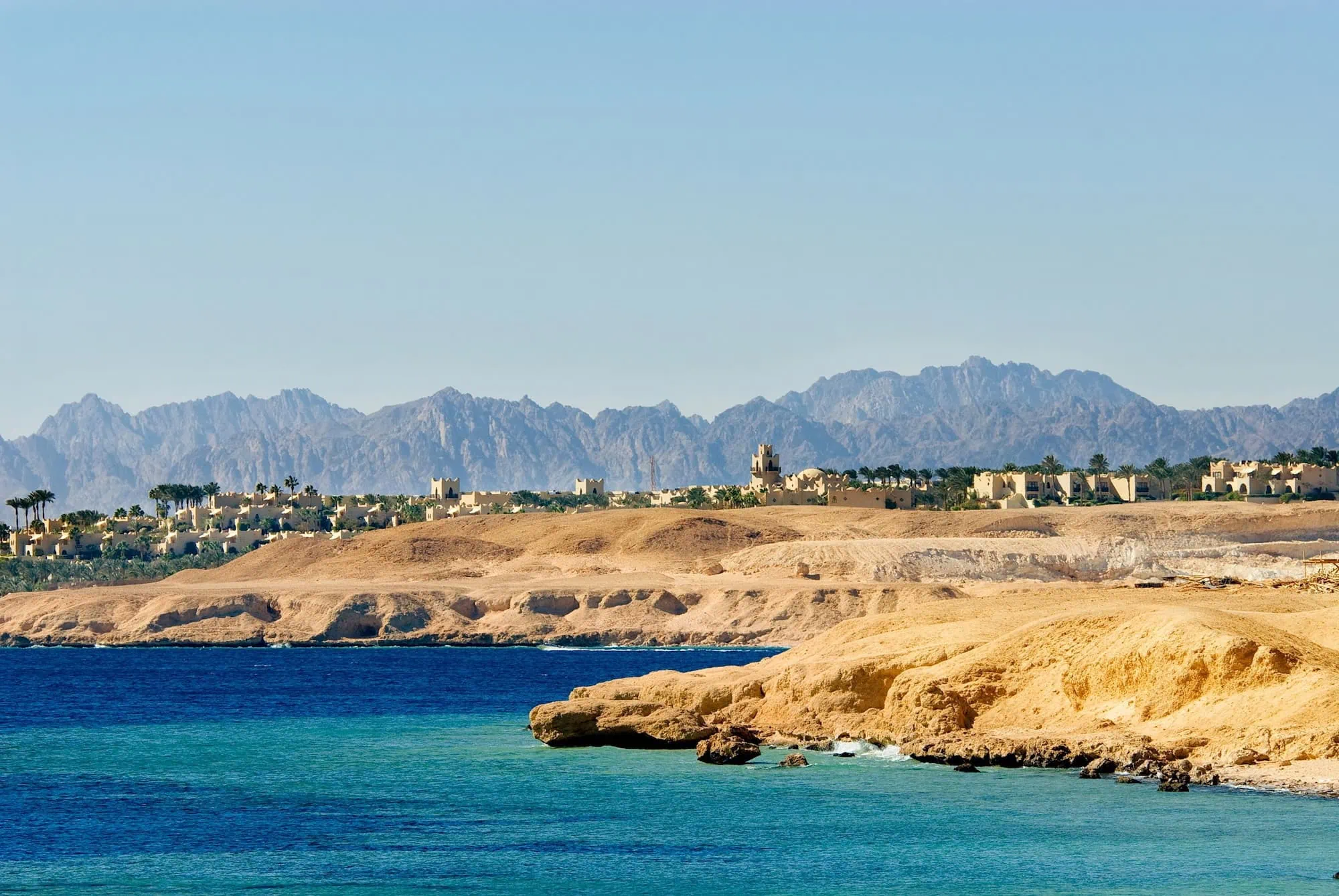 Sharm el-Sheikh coastline showing desert mountains meeting the Red Sea with resort buildings