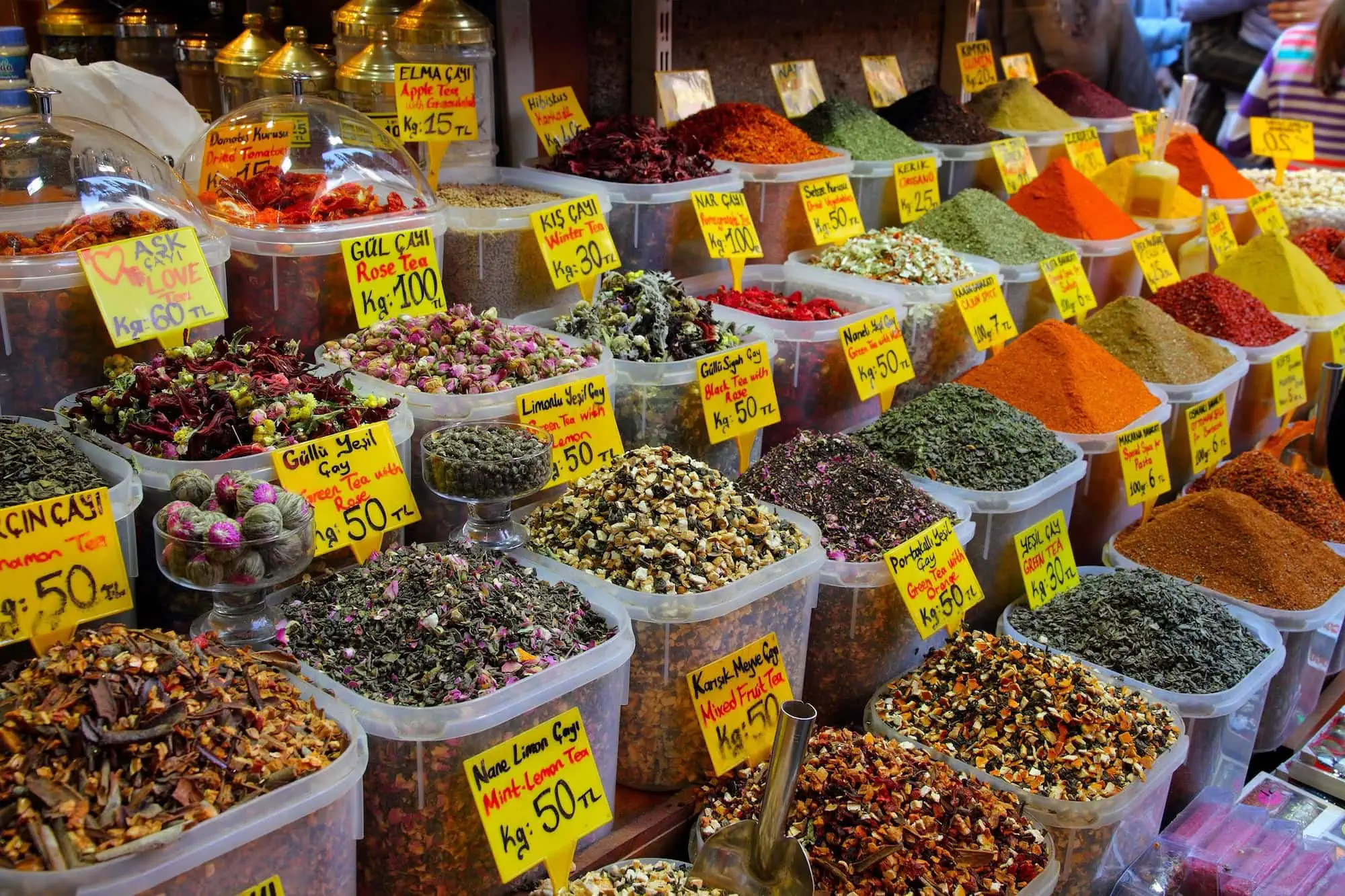 Colorful spices, teas and herbs displayed in containers at Istanbul's Spice Bazaar with price tags