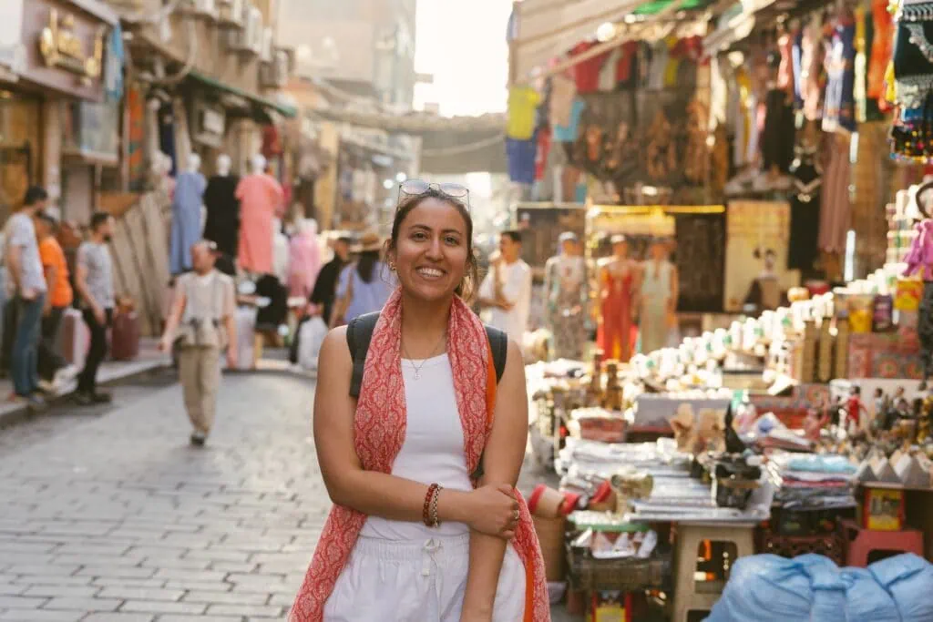 A female traveler browsing traditional metalwork and crafts inside the alleys of Khan el-Khalili bazaar in medieval Islamic Cairo