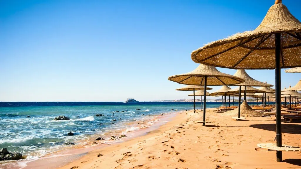 A Red Sea beach coastline with clear turquoise water and a sandy shore at Sharm El Sheikh on Egypt's Red Sea coast.