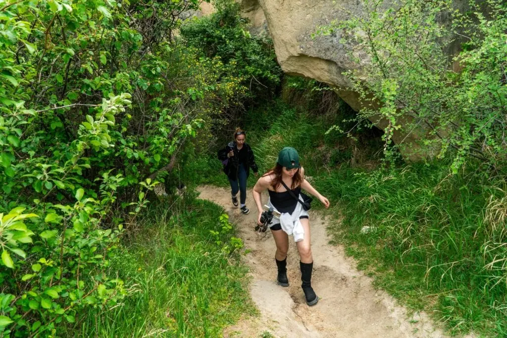 Hiking trail passing through greenery and rock formations in Pigeon Valley, Cappadocia Göreme
