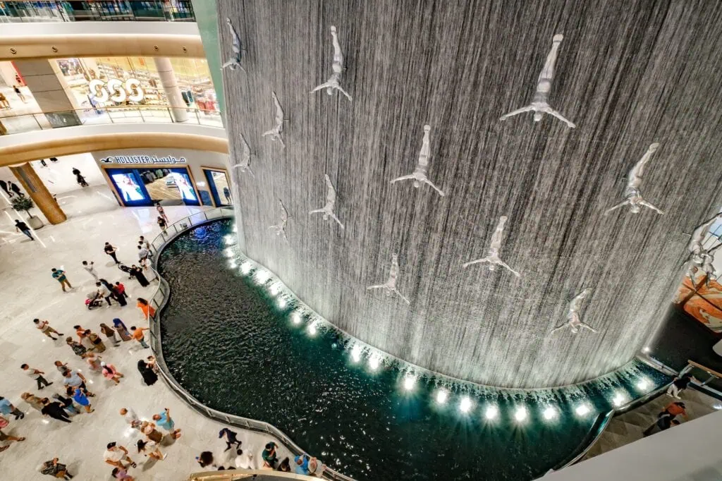 Pearl Divers Waterfall installation with suspended diver sculptures inside Dubai Mall, Dubai