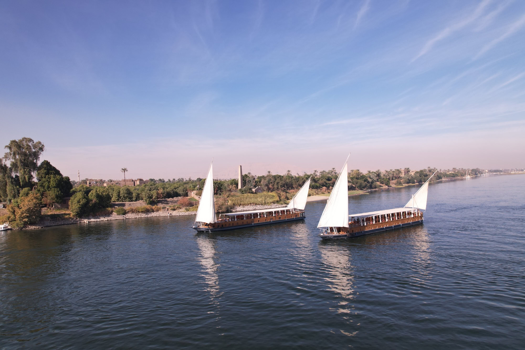 Barcos feluca navegando no Rio Nilo com velas brancas