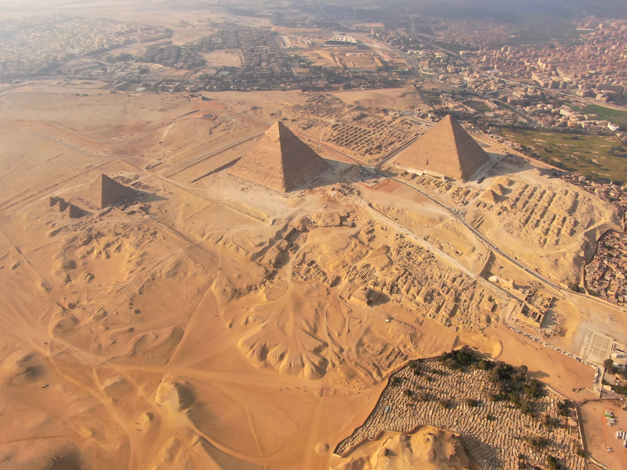 Aerial view of the Giza pyramid complex showing pyramids, sphinx, and surrounding desert landscape