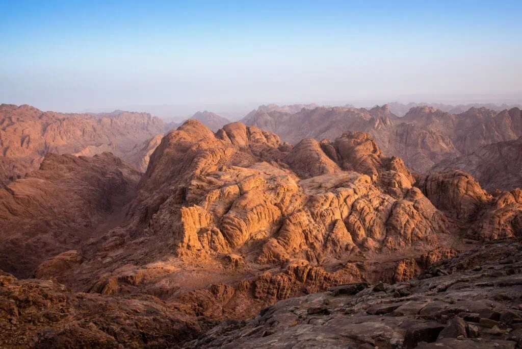 Rocky mountain peaks and winding paths seen at dawn as soft light spreads across the landscape, Mount Moses, St Catherine